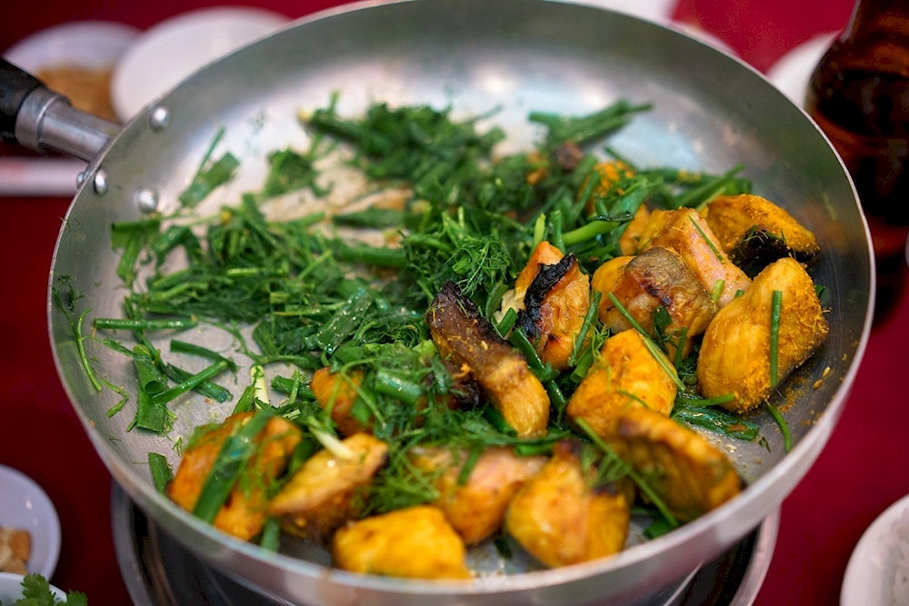 A pan of golden-brown fried fish cake, enticing and full of the Old Quarter's culinary essence